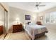Cozy secondary bedroom with a ceiling fan, shuttered windows, and hardwood floors at 17204 W Cordova Ct, Surprise, AZ 85387