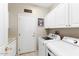 Convenient laundry room with front-loading washer and dryer, storage cabinets, and utility sink at 17204 W Cordova Ct, Surprise, AZ 85387