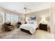 Bright main bedroom with a ceiling fan, shuttered windows, and an ensuite bathroom at 17204 W Cordova Ct, Surprise, AZ 85387