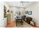 Well-lit home office with desk, wood floors, ceiling fan and plenty of natural light at 17204 W Cordova Ct, Surprise, AZ 85387
