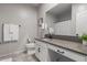 Bathroom with white cabinets, granite countertop, toilet, and decorative accents at 17452 W Andrea Dr, Surprise, AZ 85387