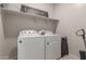 Laundry room with a washer, dryer, shelving, and laundry themed decorations at 17452 W Andrea Dr, Surprise, AZ 85387