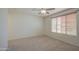Bright bedroom has neutral carpet, ceiling fan and one window with wood blinds at 18618 E Mockingbird Dr, Queen Creek, AZ 85142