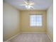 Comfortable bedroom with neutral walls, carpet, a ceiling fan, and a window for natural light at 18618 E Mockingbird Dr, Queen Creek, AZ 85142