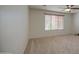 Bright bedroom has neutral carpet, ceiling fan and one window with wood blinds at 18618 E Mockingbird Dr, Queen Creek, AZ 85142