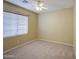 Inviting bedroom featuring neutral carpet, a window with blinds, and a ceiling fan for comfort at 18618 E Mockingbird Dr, Queen Creek, AZ 85142