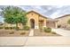 Inviting single-story home with desert landscaping, an arched entryway and a two car garage at 18618 E Mockingbird Dr, Queen Creek, AZ 85142