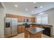 Well-lit kitchen features a stainless steel refrigerator, an island, and wooden cabinets at 18618 E Mockingbird Dr, Queen Creek, AZ 85142