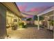 Backyard patio featuring a covered seating area, pergola, pavers, and well-manicured landscaping at 18635 W Miami St, Goodyear, AZ 85338
