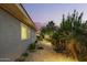 Lush backyard with a paved walkway, accent lighting, and beautiful tropical landscaping at 18635 W Miami St, Goodyear, AZ 85338