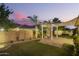 Backyard featuring a covered patio, white pergola, desert landscaping, and an inviting outdoor space at 18635 W Miami St, Goodyear, AZ 85338