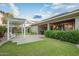 Well-maintained backyard featuring a covered patio, outdoor seating, and a lush lawn with mature landscaping at 18635 W Miami St, Goodyear, AZ 85338