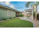 Spacious backyard with lush green lawn, covered patio, and a white pergola perfect for outdoor entertaining at 18635 W Miami St, Goodyear, AZ 85338