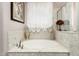 Bathroom featuring a soaking tub with elegant fixtures and marble-like tile at 18635 W Miami St, Goodyear, AZ 85338