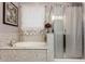 Bright bathroom features a soaking tub with elegant fixtures and a separate glass-enclosed shower at 18635 W Miami St, Goodyear, AZ 85338