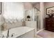 Relaxing bathroom with a soaking tub, marble tile, and a glass-enclosed shower at 18635 W Miami St, Goodyear, AZ 85338