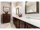 Primary bathroom featuring dual sinks with marble countertops and dark wood cabinetry at 18635 W Miami St, Goodyear, AZ 85338