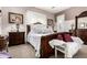Opulent bedroom boasts a carved wood bed frame, plush bedding, and dark wood furniture at 18635 W Miami St, Goodyear, AZ 85338