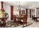 Elegant dining room with a chandelier, formal table setting, and patterned rug at 18635 W Miami St, Goodyear, AZ 85338