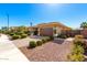 Earth-toned home with a paver driveway, manicured landscaping, gravel, and an American flag on a clear, blue-sky day at 18635 W Miami St, Goodyear, AZ 85338