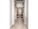 Hallway view with decorative artwork on the walls, tiled floors, and a chandelier hanging from the ceiling at 18635 W Miami St, Goodyear, AZ 85338