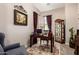 A well-organized home office with a spacious desk, elegant furnishings, and a curio cabinet at 18635 W Miami St, Goodyear, AZ 85338