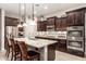 Modern kitchen featuring an island with seating, stainless steel appliances, and dark wood cabinetry at 18635 W Miami St, Goodyear, AZ 85338