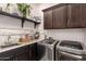 Functional laundry room features modern machines, counter space, and storage cabinets at 18635 W Miami St, Goodyear, AZ 85338