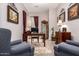 Well-appointed home office with dark wood desk, display cabinet, and dual armchairs at 18635 W Miami St, Goodyear, AZ 85338