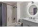Bathroom featuring shower over tub combination, white vanity with elegant marble counters and a round mirror at 18829 N 15Th Pl, Phoenix, AZ 85024