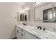 Bathroom featuring dual sinks with marble countertops and illuminated mirrors at 18829 N 15Th Pl, Phoenix, AZ 85024