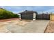 The home's garage with a black door, concrete driveway and desert landscaping at 18829 N 15Th Pl, Phoenix, AZ 85024