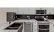 Close up of a modern kitchen featuring stainless steel appliances, black backsplash and marble countertops at 18829 N 15Th Pl, Phoenix, AZ 85024