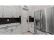 Kitchen showcases stainless steel refrigerator, white cabinets, black hardware and black backsplash at 18829 N 15Th Pl, Phoenix, AZ 85024
