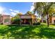 Wide view of the landscaped backyard featuring lush green lawns, patio area and desert landscaping at 19220 N 93Rd Ave, Peoria, AZ 85382