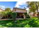 Private backyard oasis with a covered patio, manicured lawn and mature landscaping at 19220 N 93Rd Ave, Peoria, AZ 85382