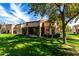 Expansive backyard featuring a covered patio area, lush green lawn, and mature shade trees at 19220 N 93Rd Ave, Peoria, AZ 85382