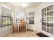 Sunlit breakfast nook features a table set for two, three large windows, and a door leading to the outside at 19220 N 93Rd Ave, Peoria, AZ 85382