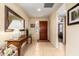 Warm and inviting foyer features tile flooring and a decorative table with a mirror at 19220 N 93Rd Ave, Peoria, AZ 85382