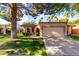 Charming single-story home featuring a well-manicured lawn and two-car garage and mature landscaping at 19220 N 93Rd Ave, Peoria, AZ 85382