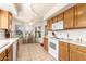 Sun-drenched kitchen boasting wood cabinetry, white appliances, tiled flooring, and a cozy breakfast nook with seating at 19220 N 93Rd Ave, Peoria, AZ 85382