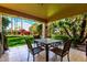 Covered patio with outdoor seating and a view of the manicured backyard at 19220 N 93Rd Ave, Peoria, AZ 85382