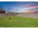 Lush backyard featuring green grass and view, framed by block fence, and firepit at 19924 W Rancho Dr, Litchfield Park, AZ 85340