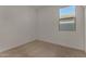 A bright, carpeted bedroom with a window offering natural light and a pleasant view at 19924 W Rancho Dr, Litchfield Park, AZ 85340