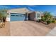 Single-story home with a blue garage door, brick driveway, and low maintenance desert landscaping at 19924 W Rancho Dr, Litchfield Park, AZ 85340