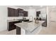 Modern kitchen featuring dark cabinets, stainless steel appliances, and a granite island at 19924 W Rancho Dr, Litchfield Park, AZ 85340