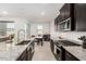 Modern kitchen with dark cabinets, stainless steel appliances, and a granite island at 19924 W Rancho Dr, Litchfield Park, AZ 85340