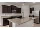 Modern kitchen with dark cabinetry, stainless steel appliances, and granite countertops with a breakfast bar at 19924 W Rancho Dr, Litchfield Park, AZ 85340