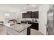 Modern kitchen with dark cabinets, stainless steel appliances, and a granite-topped island with a sink at 19924 W Rancho Dr, Litchfield Park, AZ 85340
