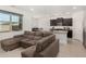 Open-concept living room featuring a large comfortable sofa, natural light, and open flow to the kitchen at 19924 W Rancho Dr, Litchfield Park, AZ 85340